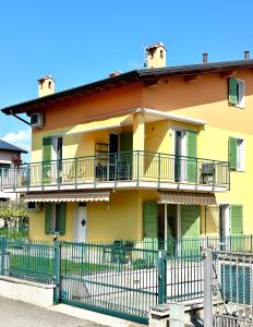 a yellow house with a fence in front of it at La Casetta Lazise in Lazise