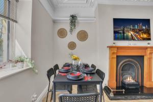 een eetkamer met een tafel en een open haard bij Cozy 2 Bedroom Cottage in West Woodburn