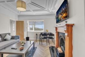 een woonkamer met een bank en een open haard bij Cozy 2 Bedroom Cottage in West Woodburn