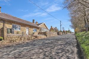 een lege straat in een dorp met huizen bij Cozy 2 Bedroom Cottage in West Woodburn