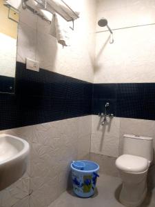 a bathroom with a white toilet and a sink at Shillong Rains Inn in Shillong