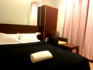 a hotel room with a bed with a towel on it at Shillong Rains Inn in Shillong