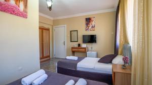 Una habitación de hotel con dos camas y un televisor. en Rayana Hotel, en Marmaris