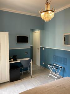 a bedroom with a blue wall with a desk and a chandelier at Oltre il Blu in La Spezia