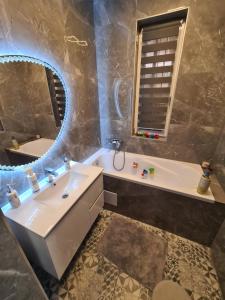 a bathroom with a sink and a tub and a mirror at Tom Apartmans 1 in Siófok +20 photos