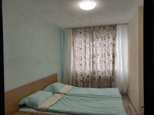 a bedroom with a bed in front of a window at BeLApartment in Petrich