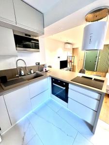 a kitchen with white cabinets and a sink at Studio La Baronne in Cannes +6 photos