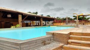 a swimming pool with a patio and a building at Pipa's Bay Apartamentos in Pipa