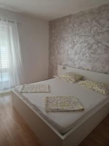 a bedroom with a bed with two pillows on it at Apartment Marta in Rab
