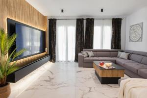 ein Wohnzimmer mit Couch und Flachbildfernseher in der Unterkunft Villa Luce in Podstrana