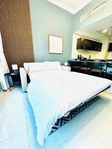 un grande letto bianco in una stanza con cucina di Bright and Modern Condo in Dubai Marina a Dubai