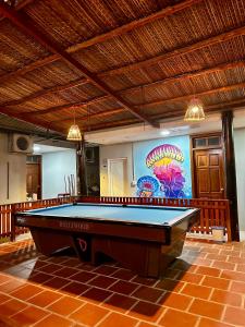 a pool table in a room with a painting on the wall at SnS Muine Homestay in Mui Ne
