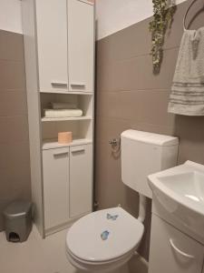 a bathroom with a white toilet and a sink at Apartman Sandra in Podstrana +25 photos