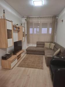a living room with a couch and a flat screen tv at Apartman Sandra in Podstrana