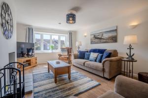 a living room with a couch and a table at Cobbles End by Winterton Cottages in Winterton-on-Sea