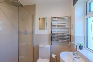 a bathroom with a toilet and a sink and a shower at Cobbles End by Winterton Cottages in Winterton-on-Sea +16 photos