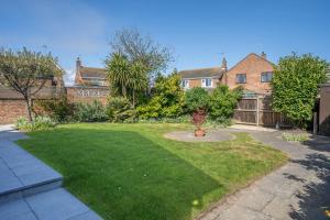 a backyard with a yard with green grass at Cobbles End by Winterton Cottages in Winterton-on-Sea