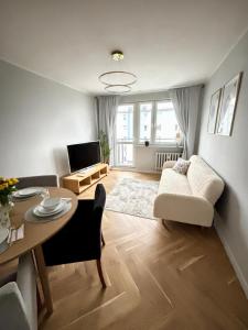 a living room with a table and a couch at Golden Bay Derdowskiego 2 in Puck