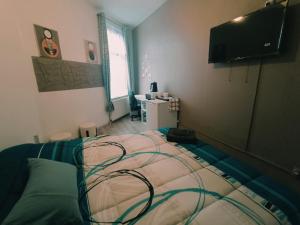 a bedroom with a bed with a television on the wall at Chez Oppo in Charleroi