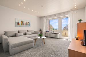a living room with a couch and a table at STAYS Hafenblick direkt am See in Hagnau
