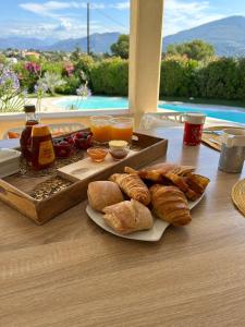 una mesa con una bandeja de pan y bollería. en Duplex Oliveraie piscine au sel marin et parking, en Niza