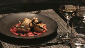 un piatto di cibo su un tavolo con un bicchiere di vino di The Blackpine Hotel - Small Luxury Hotels a Escaldes-Engordany