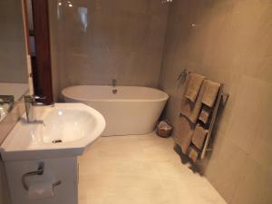 a bathroom with a white tub and a sink at Reef Cottage accommodation in Reefton