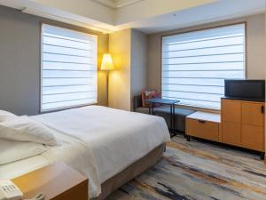 Postel nebo postele na pokoji v ubytování JR Hotel Clement Takamatsu