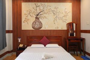 Un dormitorio con una cama con un jarrón en la pared. en Khách Sạn Khánh Vy Airport TSN - Cổng Nhà Ga T3, en Ho Chi Minh