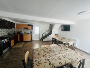 a kitchen and dining room with a table and chairs at Casa Lidia in Râu de Mori