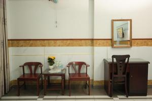 2 Stühle und ein Tisch in einem Zimmer mit Spiegel in der Unterkunft khách sạn Kim Long in Ho-Chi-Minh-Stadt