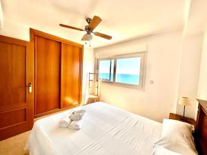 a bedroom with a bed with a ceiling fan and a window at Vistas al mar, El Puig in El Puig