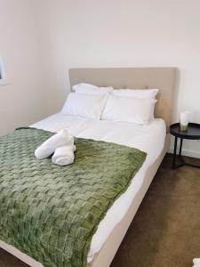 a white teddy bear sitting on a bed at Colebee 4 Bedroom House Walk to Park and Shops in Schofields