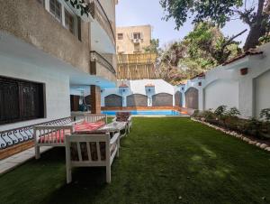 a courtyard with chairs and a lawn with a pool at Villa Maadi 35 -R 3 - Poolside Master Room in Cairo