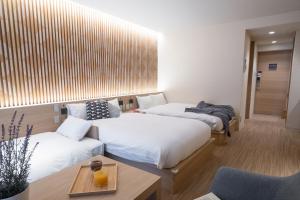 a room with two beds and a table and a couch at ORI Kyoto in Kyoto