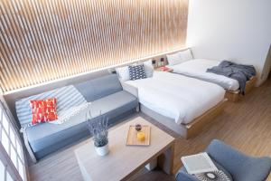 a small room with two beds and a couch at ORI Kyoto in Kyoto