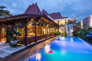 a house with a swimming pool and a gazebo at Kalynda Boutique Villa in Kejayan