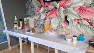 una mesa blanca con comida encima en Pousada do Vaqueiro, en Peruíbe