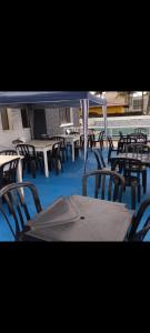 Un grupo de mesas y sillas en un patio. en Pousada do Vaqueiro, en Peruíbe