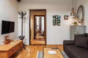 a living room with a couch and a tv at Wood House Republicii in Braşov