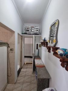 a hallway with a sink and a mirror on a wall at Apartamento - kitnet in Guarujá