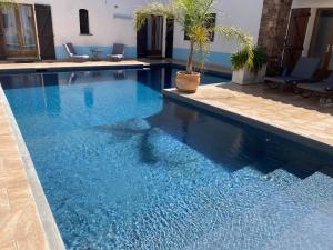 a swimming pool with blue water in a building at Le Patio Bleu in La Crau