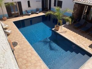 a swimming pool with blue water in a backyard at Le Patio Bleu in La Crau
