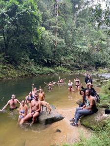 a group of people sitting on rocks in a river at Lagamar Eco Hotel in Cananéia