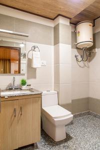 a bathroom with a toilet and a sink at The Tikker suites in Cheog