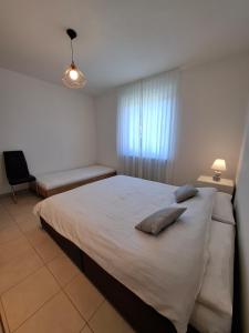 a bedroom with a large white bed and a chair at Appartamento 3,5 locali a Figino in Figino