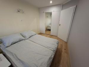 a white bedroom with a bed and a closet at Blue Mare Hebe Apartament in Łukęcin