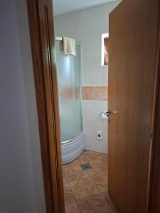 a bathroom with a shower and a glass door at House Mara in Korenica