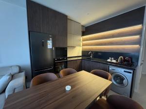a kitchen with a wooden table and a kitchen with a dishwasher at Sea Breeze, "Park Residence-2" in Baku