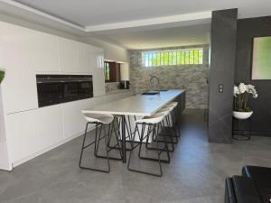 una cucina con isola e sgabelli da bar di Villa avec piscine a Montauban